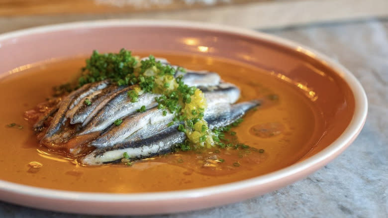 whole anchovies on plate in oil