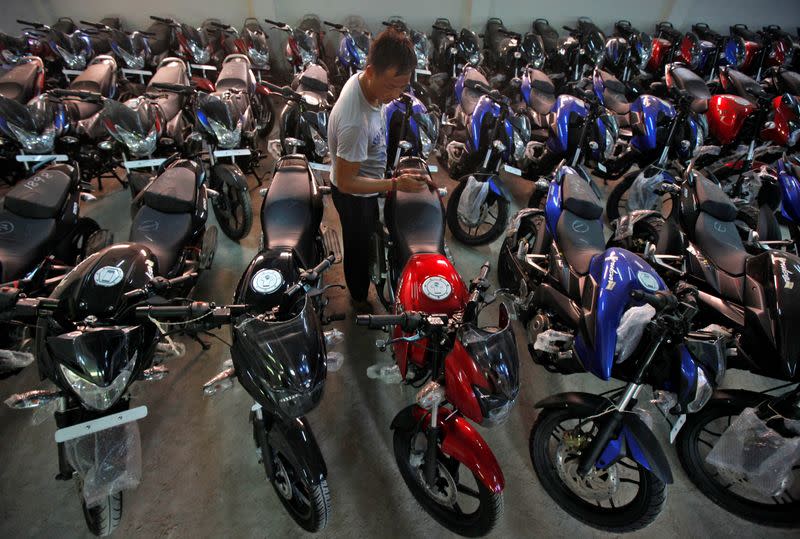 FILE PHOTO: Worker cleans Bajaj motorcycle at a Bajaj showroom in Kolkata