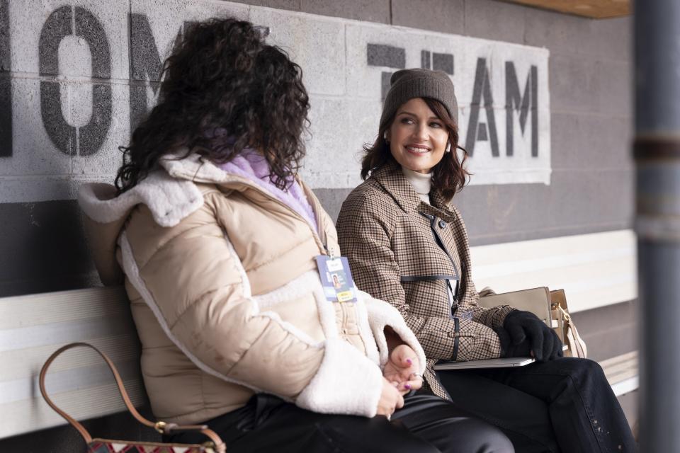 Carla Gugino sitting next to another person in Girls on the Bus