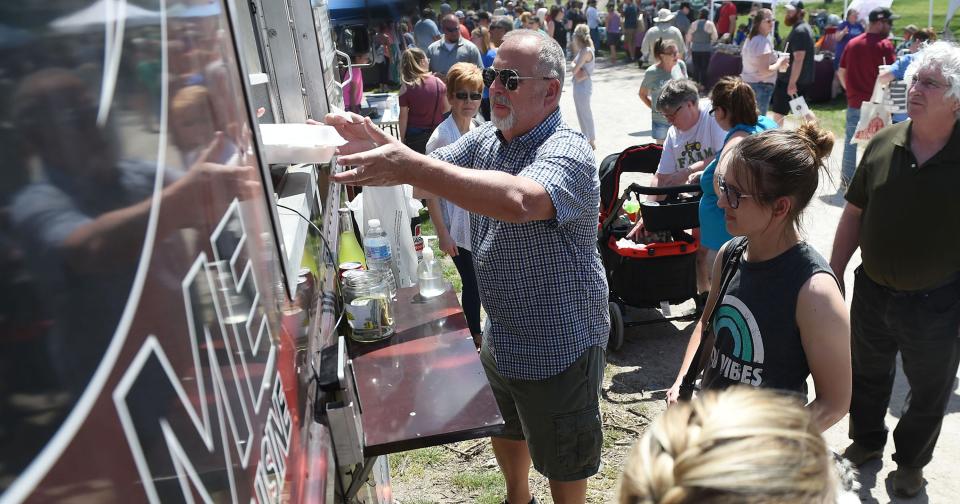 People buy food at a food truck at the Maxwell Market in the Park May 2, 2021, in Maxwell.