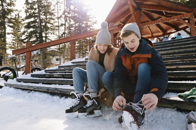 couple putting on ice skates in the snow