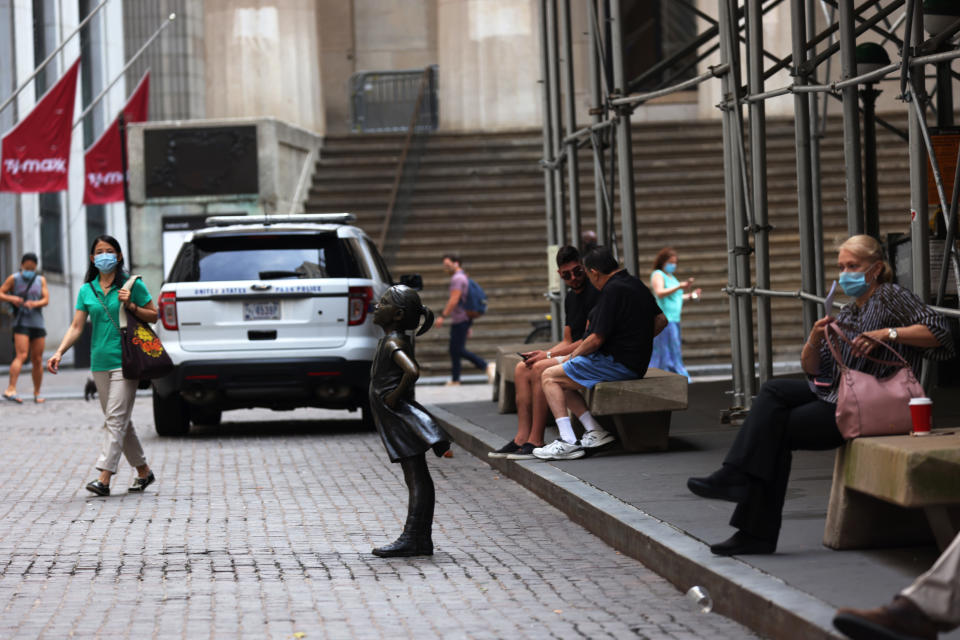 NEW YORK, NEW YORK - JULY 23: People walk near the "Fearless Girl" statue in front of the New York Stock Exchange (NYSE) at Wall Street on July 23, 2020 in New York City. On Wednesday July 22, the market had its best day in 6 weeks. (Photo by Michael M. Santiago/Getty Images)