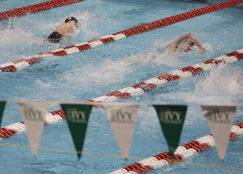 Pennsylvania's Lia Thomas, right, races Yale's Iszak Henig in the 100-yard freestyle final at the Ivy League women's swimming and diving championships at Harvard University, Saturday, Feb. 19, 2022, in Cambridge, Mass. Henig, who is transitioning to male but has not begun hormone treatments yet, is swimming for the Yale women's team and Thomas, who is transitioning to female, is swimming for the Penn women's team. (AP Photo/Mary Schwalm)