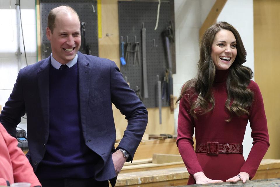 Prince William, Duke of Cornwall and Catherine Duchess of Cornwall share a joke with local people working in the boat building workshop during their tour of the National Maritime Museum Cornwall