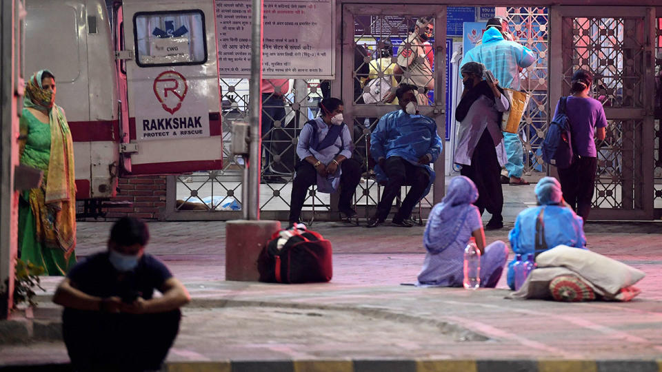 Pictured here, family members wait outside an emergency centre as loved ones are treated for Covid-19 symptoms.