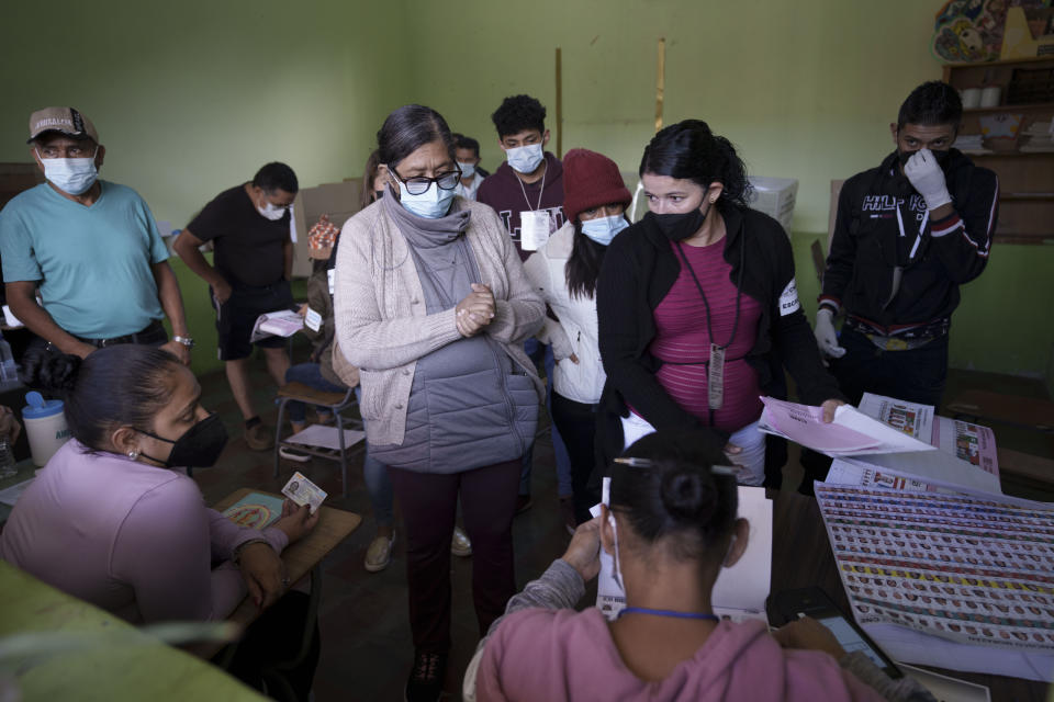 Voters wait for their ballots a polling station during general elections in Tegucigalpa, Honduras, Sunday, Nov. 28, 2021. (AP Photo/Moises Castillo)
