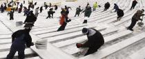 Paid volunteers clear snow from the bleachers at Lambeau Field in Green Bay, Wisconsin, the home field of the Green Bay Packers of the National Football League (NFL), December 21, 2013. In winter months, the team calls on the help of hundreds of citizens, who also get paid a $10 per-hour wage, to shovel snow and ice from the seating area ahead of games, local media reported. The Packers will host the Pittsburgh Steelers on Sunday, December 22. REUTERS/Mark Kauzlarich (UNITED STATES - Tags: ENVIRONMENT SPORT FOOTBALL)