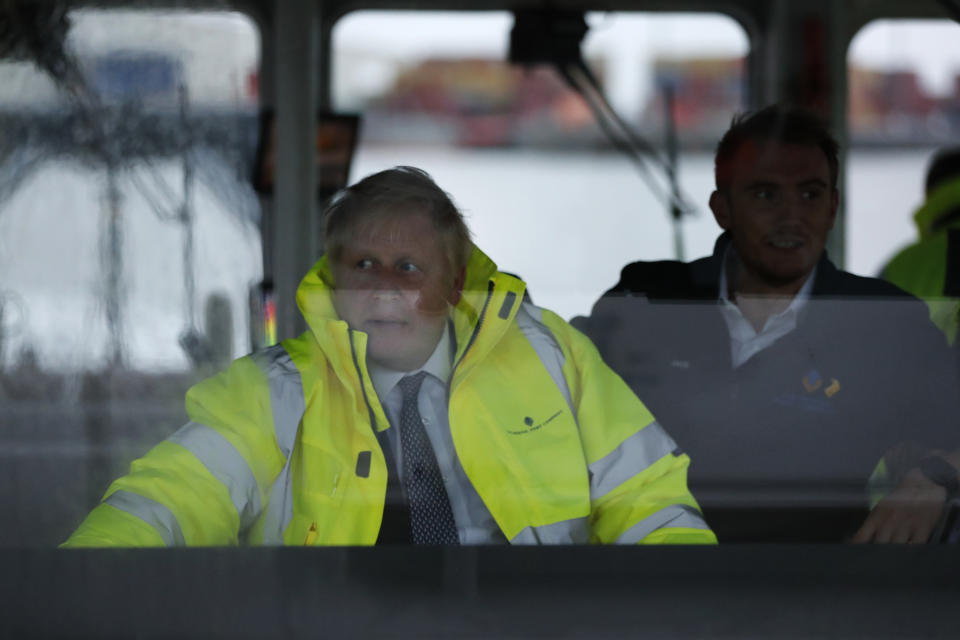 Britain's Prime Minister Boris Johnson steers a tug boat during a General Election campaign stop in the port of Bristol, England, Thursday, Nov. 14, 2019. Britain goes to the polls on Dec. 12. (AP Photo/Frank Augstein, Pool)