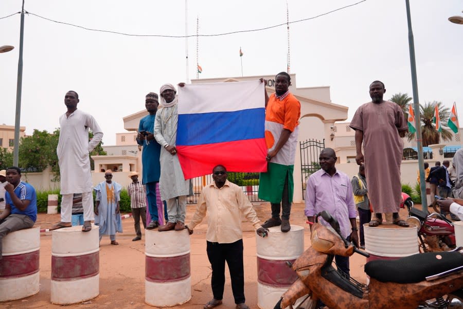 Supporters of mutinous soldiers hold a Russian flag as they demonstrate in Niamey, Niger, Thursday July 27 2023. (AP Photo/Sam Mednick)