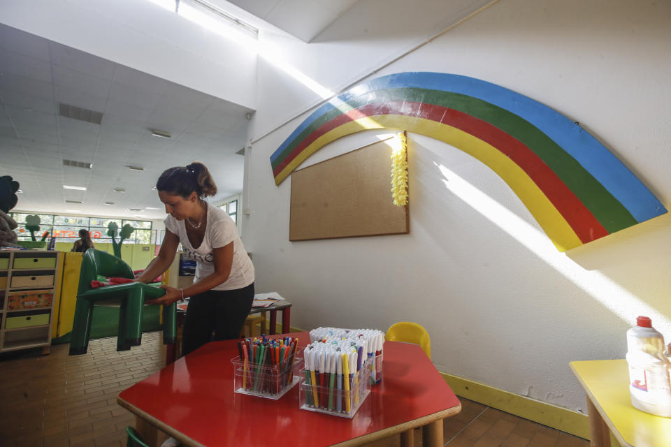 A worker cleans up the playroom in the 'La Giostra Nel Parco' (Merry go around in the park) nursery school in Milan, northern Italy, Thursday, Aug. 27, 2020, ahead of reopening. Despite a spike in coronavirus infections, authorities in Europe are determined to send children back to school. Italy, Europe’s first virus hot spot, is hiring 40,000 more temporary teachers and ordering extra desks, but some won’t be ready until October. (AP Photo/Luca Bruno)