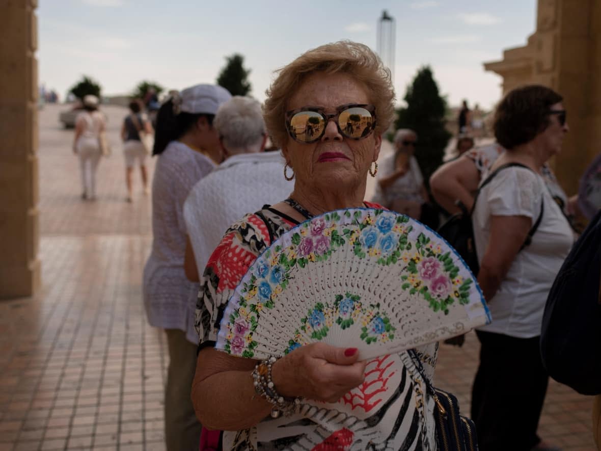 A woman cools off with a fan during a heat wave in Córdoba, Spain on Thursday. Spain and neighbouring Portugal have seen temperatures hitting the mid- to high-30s C in the final week of April. (Jorge Guerrero/AFP/Getty Images - image credit)