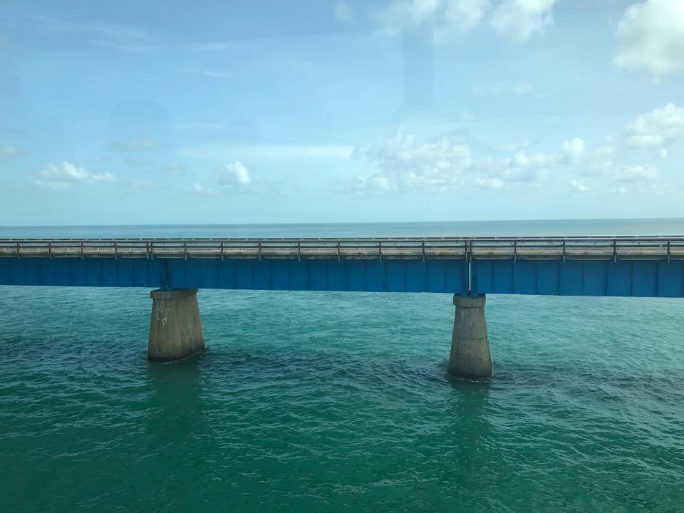 Turquoise waters below a concrete bridge