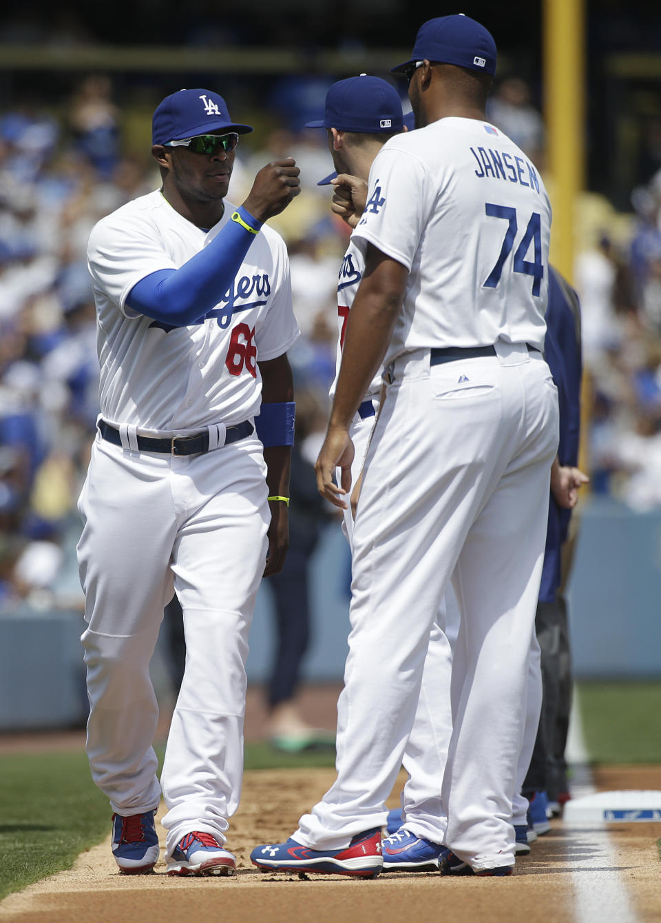 Los Angeles Dodgers' Yasiel Puig, left, is greeted by relief pitcher Kenley Jansen as he is introduced before a baseball game against the San Francisco Giants, Friday, April 4, 2014, in Los Angeles. Puig arrived late to the ballpark and was removed from the batting order. (AP Photo/Jae C. Hong)