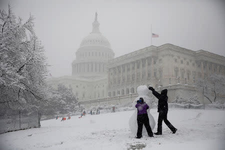 People build a snowman outside the U.S. Capitol in Washington, U.S., March 21, 2018. REUTERS/Aaron P. Bernstein