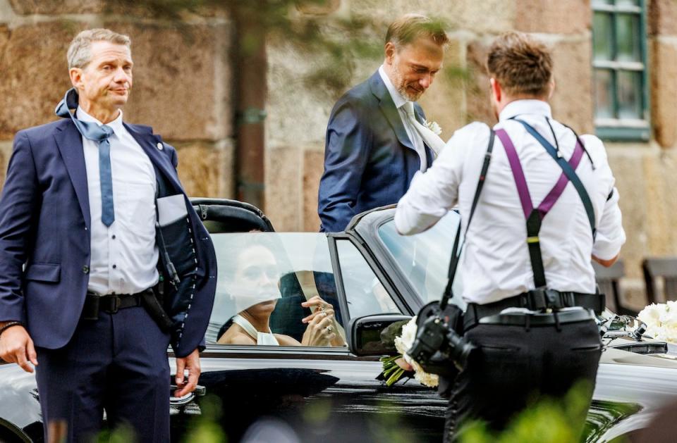 Bundesfinanzminister Christian Lindner (FDP, M) und seine Frau Franca Lehfeldt kommen nach der kirchlichen Trauung aus der Kirche St. Severin, im Vordergrund steht ein Sicherheitsmann. 