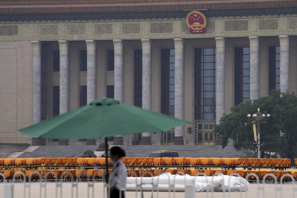 A security person stands on duty near rows of yellow sets setup in front of the Great Hall of the People on Tiananmen Square in Beijing on Wednesday, June 23, 2021. Chinese authorities have closed Beijing's central Tiananmen Square to the public, eight days ahead of a major celebration being planned to mark the 100th anniversary of the founding of the ruling Communist Party. (AP Photo/Andy Wong)