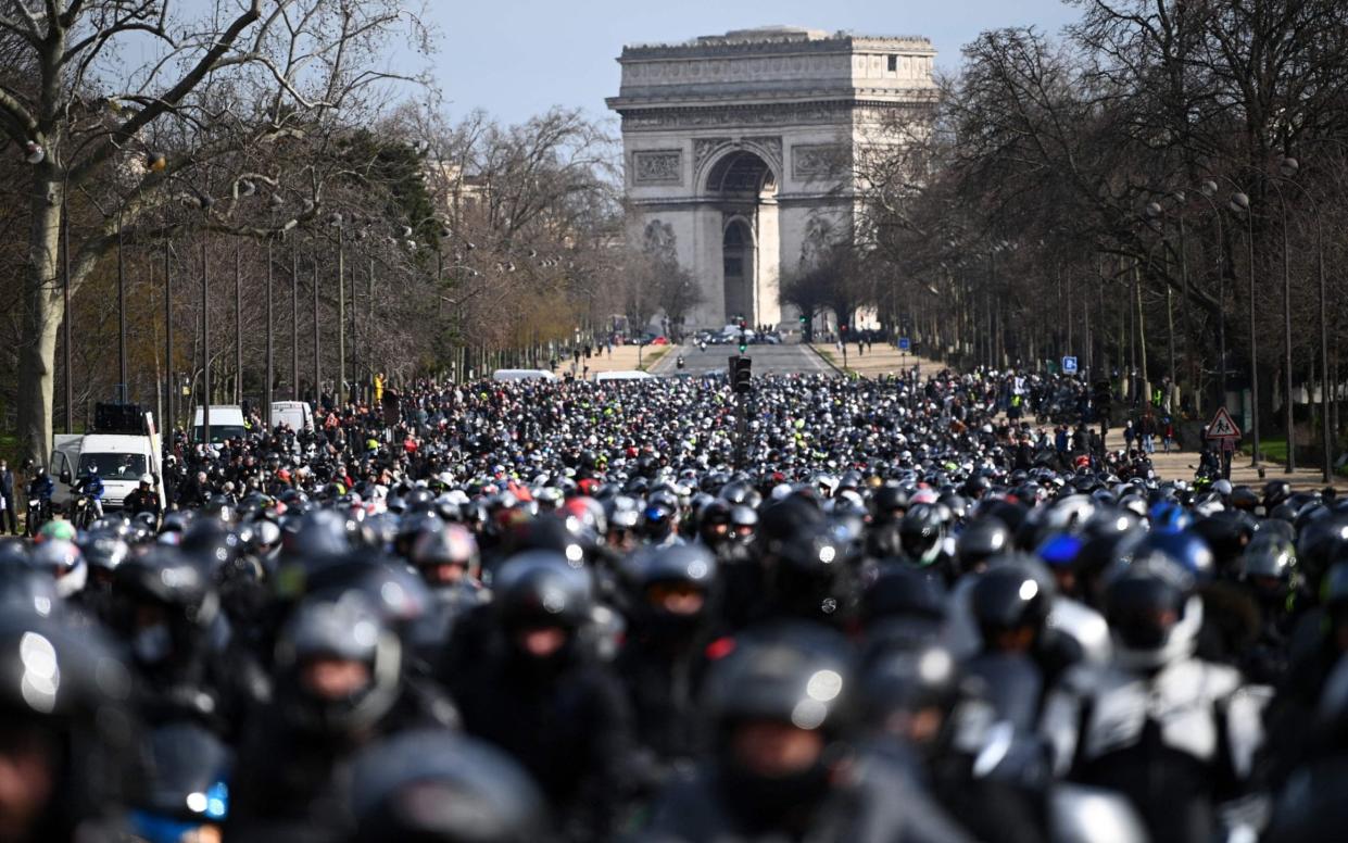 Weaving their way... motorcyclists ride together on Paris's Champs-Elysee avenue  - AFP