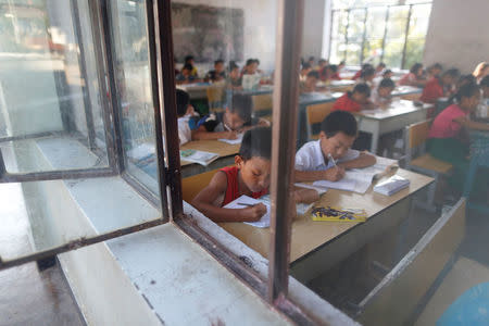 Students write in books during a Chinese language lesson in a school at Namtit, Wa territory in northeast Myanmar September 30, 2016. REUTERS/Soe Zeya Tun