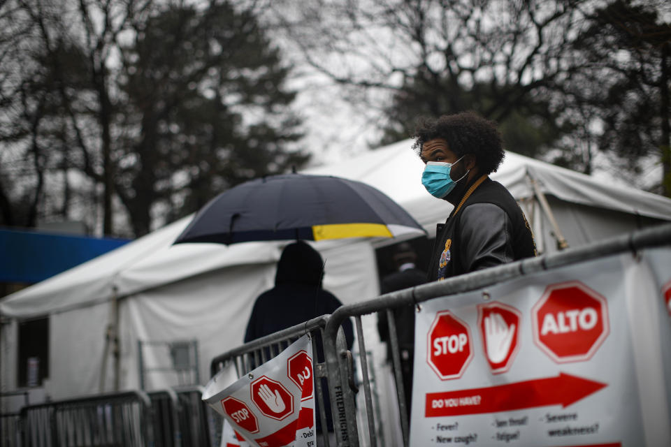 Patients wait in line while wearing protective masks and gloves for a COVID-19 test at Brooklyn Hospital Center, Sunday, March 29, 2020, in Brooklyn borough of New York. The new coronavirus causes mild or moderate symptoms for most people, but for some, especially older adults and people with existing health problems, it can cause more severe illness or death. (AP Photo/John Minchillo)