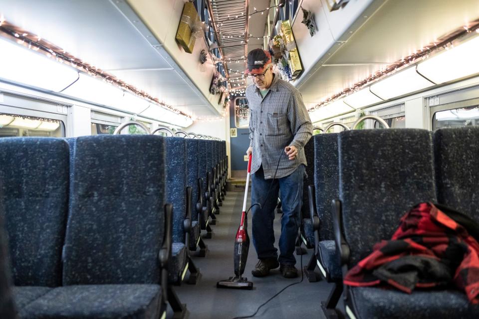 Volunteer Steve Wheeler, of Owosso, vacuums a double deck car as they get ready for the first day of the North Pole Express at the Steam Railroading Institute in Owosso on Friday, Nov. 17, 2023.