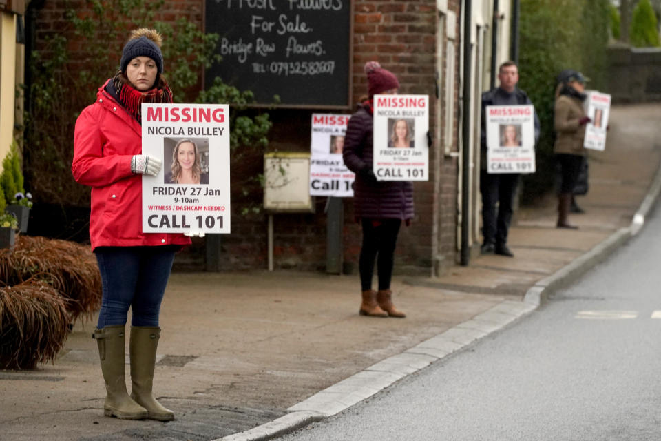 Friends of missing woman Nicola Bulley hold missing person appeal posters along the main road in St Michael's on Wyre on Friday. (PA)