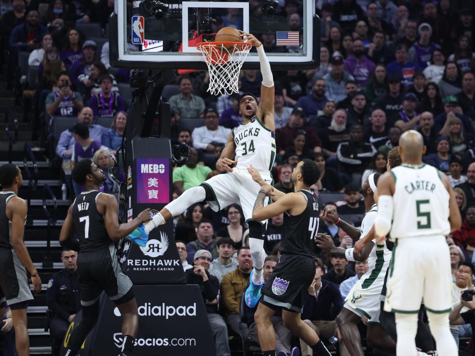 Bucks power forward Giannis Antetokounmpo throws down a dunk against Kings center Trey Lyles (right) during the first quarter Monday night.