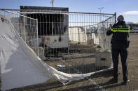 A police officer takes images of a torched coronavirus testing facility in the Dutch fishing village of Urk, Sunday, Jan. 24, 2021, after it was torch Saturday night by rioting youths protesting on the first night of a nation-wide curfew. (AP Photo/Peter Dejong)