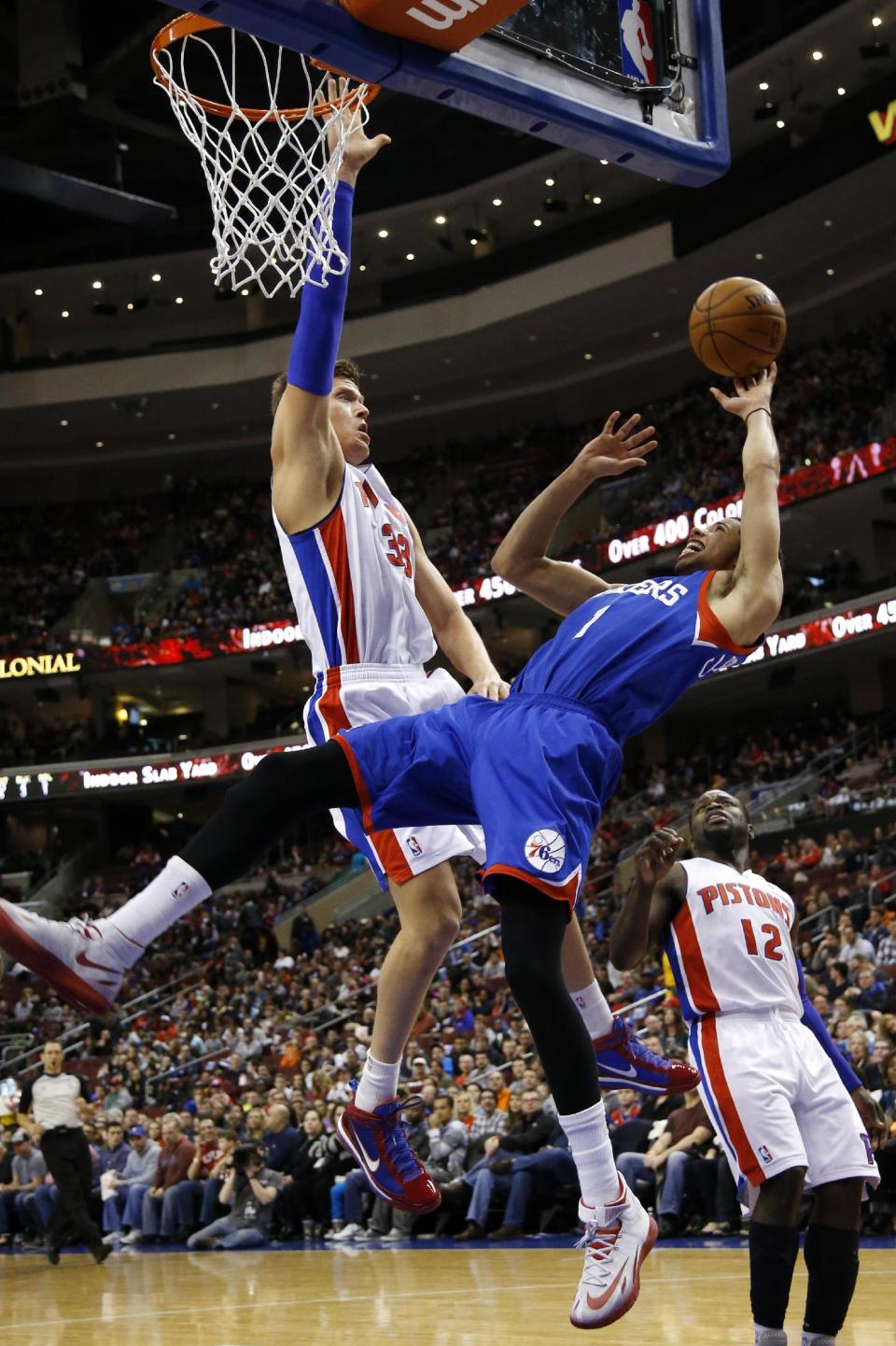 Philadelphia 76ers' Michael Carter-Williams (1) goes up to shoot against Detroit Pistons' Jonas Jerebko (33), of Sweden, and Will Bynum (12) during the first half of an NBA basketball game on Saturday, March 29, 2014, in Philadelphia. (AP Photo/Matt Slocum)