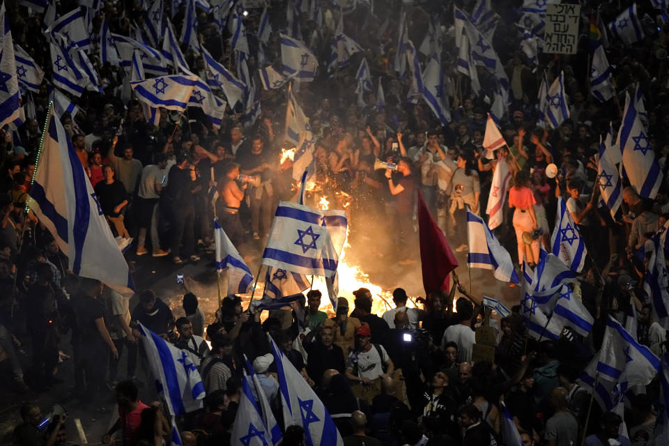 Israelis opposed to Prime Minister Benjamin Netanyahu's judicial overhaul plan set up bonfires and block a highway during a protest moments after the Israeli leader fired his defense minister, in Tel Aviv, Israel, Sunday, March 26, 2023. Defense Minister Yoav Gallant had called on Netanyahu to freeze the plan, citing deep divisions in the country and turmoil in the military. (AP Photo/Ohad Zwigenberg)