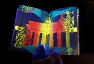 <p>The new German electronic passport is pictured under an ultraviolet light during its presentation to the media in Berlin, Germany, Feb. 23, 2017. (Photo: Fabrizio Bensch/Reuters) </p>