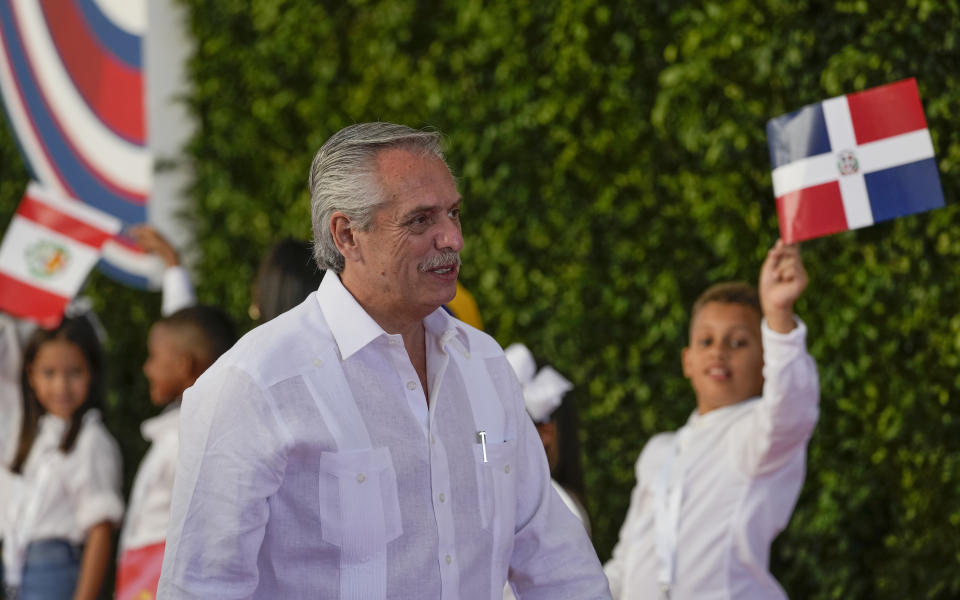 El presidente de Argentina, Alberto Fernández, camina junto a unos niños que ondean banderas a su llegada a la sesión de la 28va Cumbre Iberoamericana, en Santo Domingo, República Dominicana, el sábado 25 de marzo de 2022. (Foto AP/Ariana Cubillos)