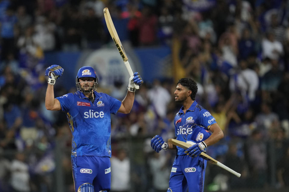 Mumbai Indian's Tilak Varma, right, celebrates along with Mumbai Indian's Tim David their team win against Rajasthan Royals during the Indian Premier League cricket match in Mumbai, India, Sunday, April 30, 2023. (AP Photo/Rajanish Kakade)