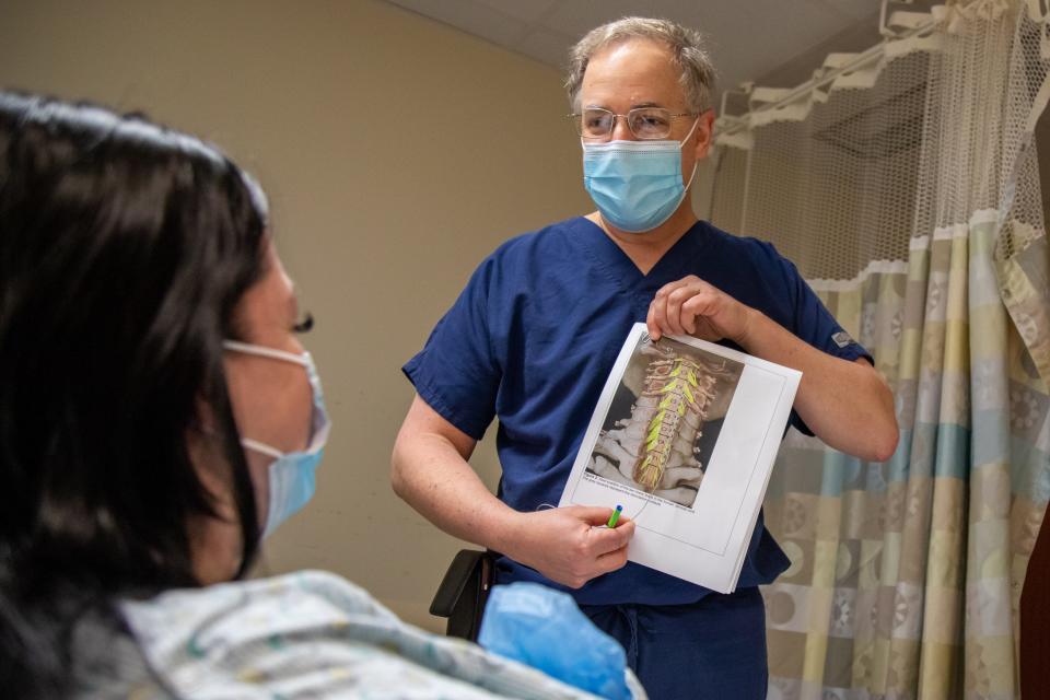 Neurosurgeon Peter Gerszten explains the electrodes’ implantation procedure to study participant Heather Rendulic at UPMC Presbyterian hospital.