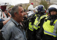 Riot police face protesters who took part in a 'We Do Not Consent' rally at Trafalgar Square, organised by Stop New Normal, to protest against coronavirus restrictions, in London, Saturday, Sept. 26, 2020. (AP Photo/Frank Augstein)