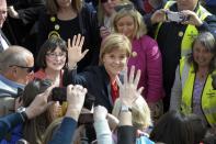 Scottish First Minister and leader of the Scottish National Party (SNP), Nicola Sturgeon (C), waves to members of the public in Largs, Scotland on May 4, 2015