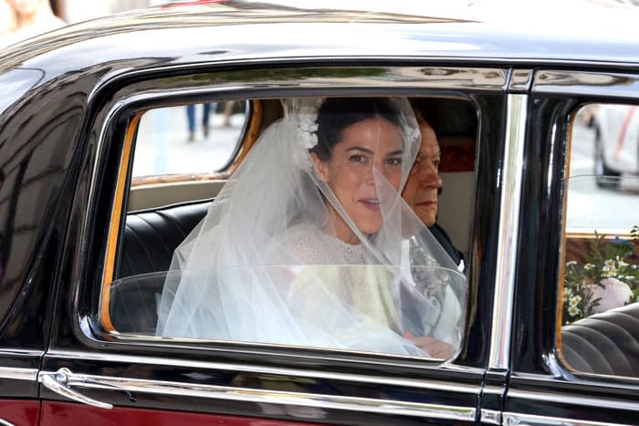 La novia llega en el coche nupcial acompañada por el padrino