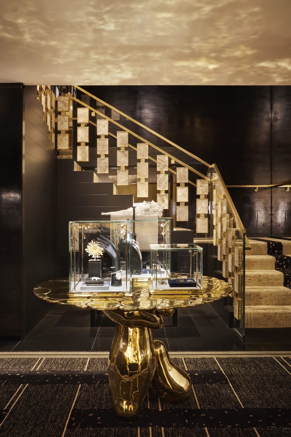 a glass display case with a gold statue in front of a staircase