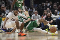 Cleveland Cavaliers guard Darius Garland, left, and Boston Celtics forward Jayson Tatum fall after reaching for the ball during the first half of Game 3 of an NBA basketball second-round playoff series Saturday, May 11, 2024, in Cleveland. (AP Photo/Sue Ogrocki)