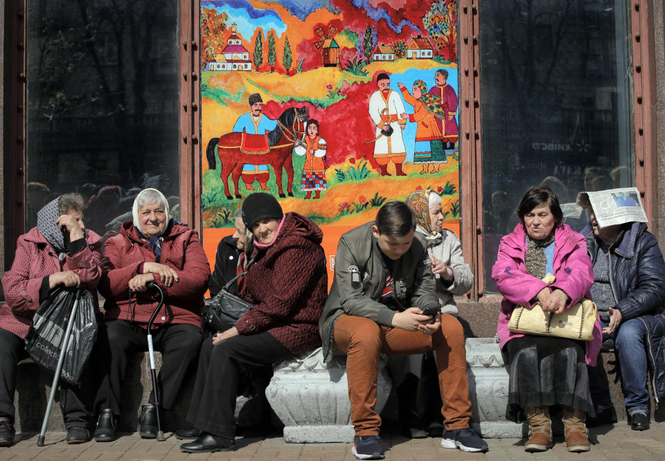 People sit on a sunny morning in Kiev, Ukraine, Thursday, April 18, 2019. The second round of presidential voting in Ukraine will take place on upcoming Sunday April 21. (AP Photo/Vadim Ghirda)