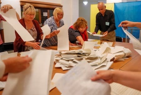 Members of a local electoral commission count ballots at a polling station after a parliamentary election in Kiev