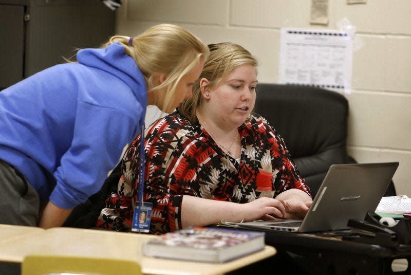 Kaitlin Fuerstenau, center, a U.S. history student teacher at Central High School in North Dakota, answers a question from Adrianna Hase before class in 2016.