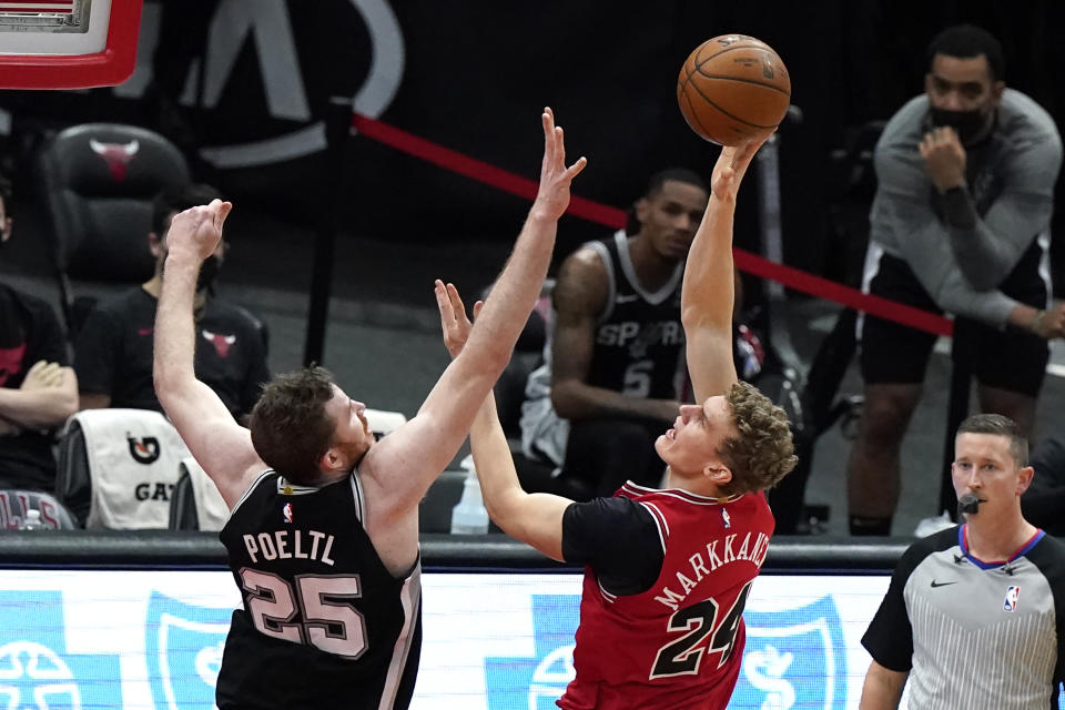 Chicago Bulls forward Lauri Markkanen, right, shoots against San Antonio Spurs center Jakob Poeltl during the first half of an NBA basketball game in Chicago, Wednesday, March 17, 2021. (AP Photo/Nam Y. Huh)