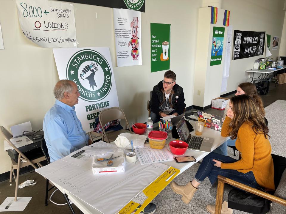 Richard Bensinger, left, who is advising unionization efforts, along with baristas Casey Moore, right, Brian Murray, second from left, and Jaz Brisack, second from right, discuss their efforts to unionize three Buffalo-area stores, inside the movements headquarters on Thursday, Oct. 28, 2021 in Buffalo, N.Y. Workers at three Starbucks stores in Buffalo will hold union elections next month after winning a case before the National Labor Relations Board.(AP Photo/Carolyn Thompson).