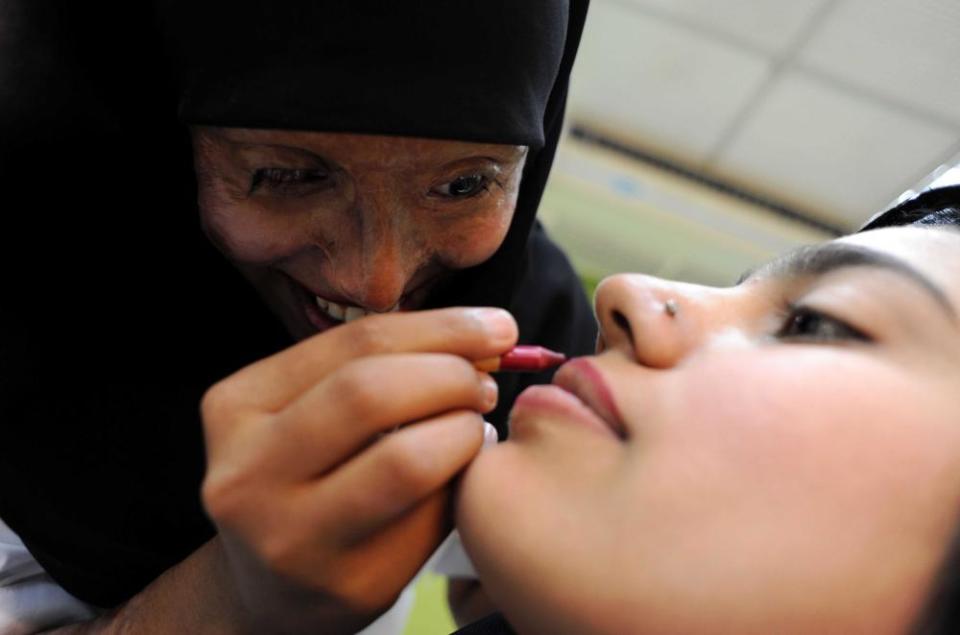 Saria, 22, does the makeup for a woman at the Depilex beauty salon in Lahore, Pakistan. Saria’s fiancé threw acid over her when she resisted his attempts to take her away from her family home by force.