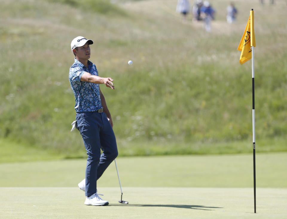 United States' Collin Morikawa gives his ball to his caddie on the 3rd hole during the final round of the British Open Golf Championship at Royal St George's golf course Sandwich, England, Sunday, July 18, 2021. (AP Photo/Peter Morrison)