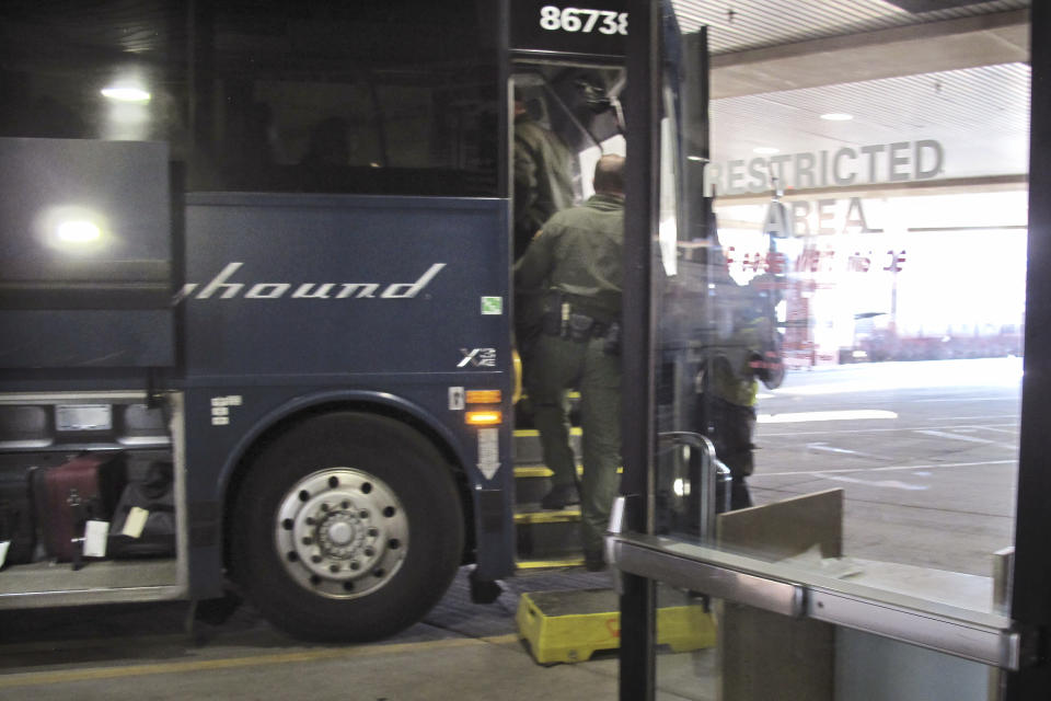 FILE - In this Thursday, Feb. 13, 2020 file photo, agents for Customs and Border Protection board a Greyhound bus headed for Portland, Ore., at the Spokane Intermodal Center, a terminal for buses and Amtrak, in Spokane, Wash. Greyhound, the nation's largest bus company, says it will stop allowing Border Patrol agents without a warrant to board its buses to conduct routine immigration checks. The company announced the change Friday, Feb. 21, 2020, one week after The Associated Press reported on a leaked Border Patrol memo confirming that agents can't board private buses without the consent of the bus company. (AP Photo/Nicholas K. Geranios,File)