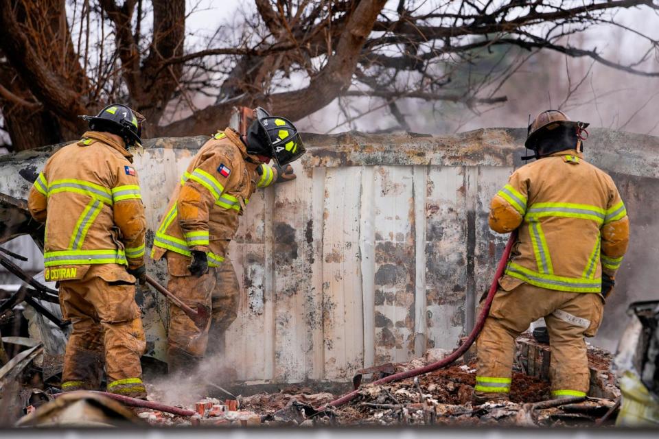 PHOTO: Fire officials from Lubbock, Texas, help put out smoldering debris of a home destroyed by the Smokehouse Creek Fire, Thursday, Feb. 29, 2024, in Stinnett, Texas. (Julio Cortez/AP)