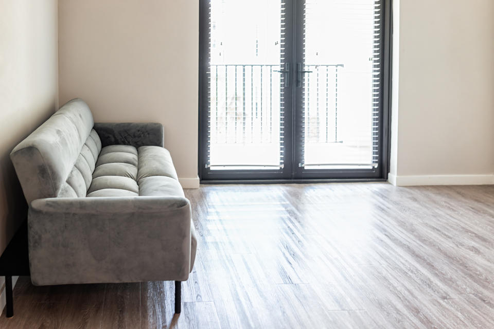 A couch in an otherwise empty apartment