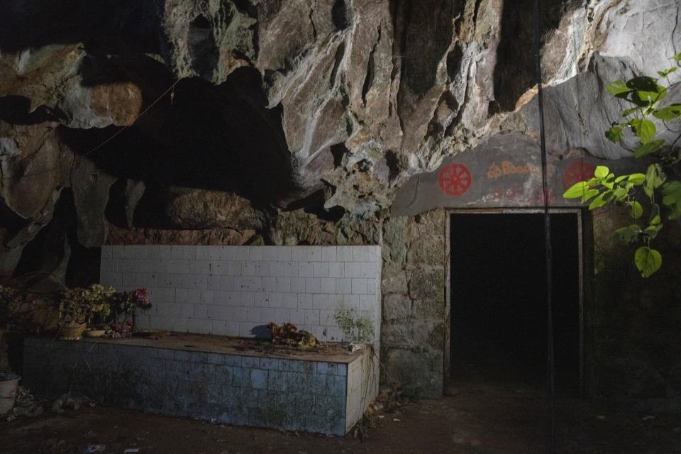 The entrance to the abandoned Wanling cave is littered with religious paraphernalia near Manhaguo village in southern China's Yunnan province on Wednesday, Dec. 2, 2020. Villagers said the cave had been used as a sacred altar presided over by a Buddhist monk _ precisely the kind of contact between bats and people that alarms scientists. (AP Photo/Ng Han Guan)