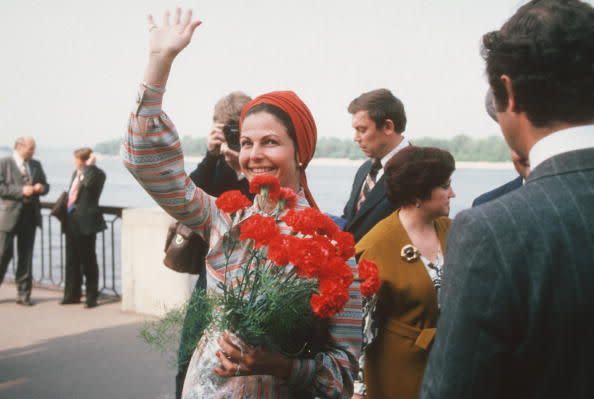 <p>Queen Silvia, red carnations in hand, waved to onlookers during a visit to Uzbekistan.</p>